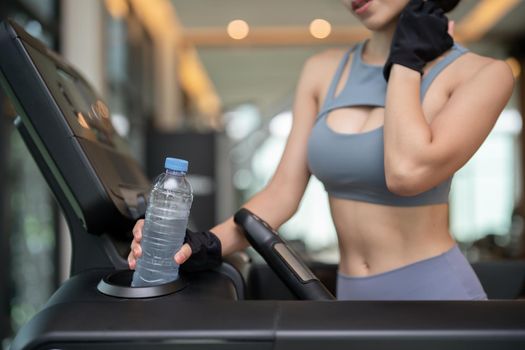 Woman drink water from plastic bottle after workout.