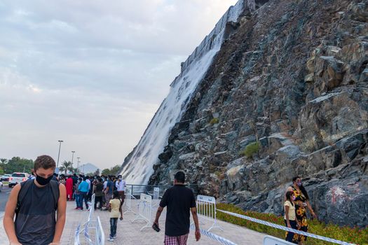 Sharjah, UAE - 07.20.2021 - Visitors at Sharjah amphitheatre waterfall, Khor Fakkan area.