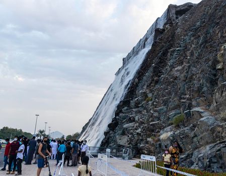 Sharjah, UAE - 07.20.2021 - Visitors at Sharjah amphitheatre waterfall, Khor Fakkan area.