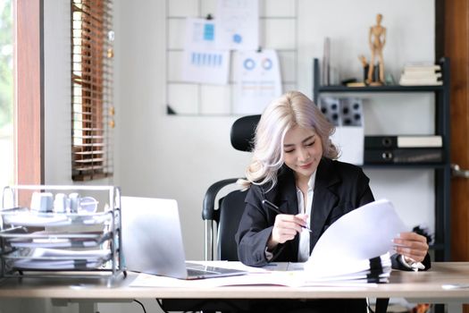 Asian businesswoman working in the office with working documents..