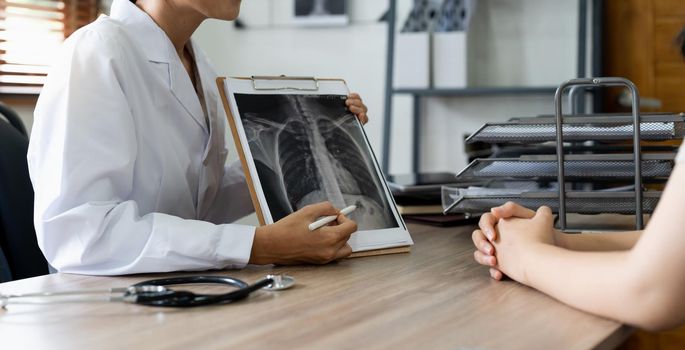 Doctor showing x-ray result to patient in clinic.