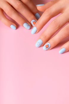 Female hands with winter snow manicure with stickers under a matte top on pink background.