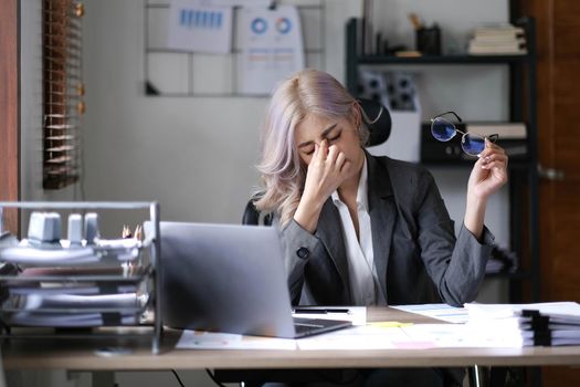 Asian business woman is stressful. bored at work and thinking a lot from unsuccessful work at the office..