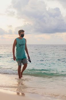 Teenage boy walking on the beach