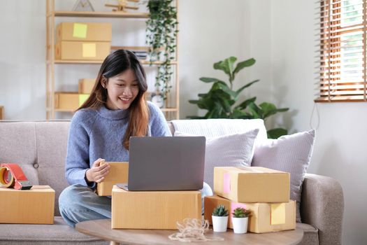 Starting Small business entrepreneur freelance, Portrait young woman working at home office, BOX, smartphone, laptop, online, marketing, packaging, delivery, b2b, SME, e-commerce concept.