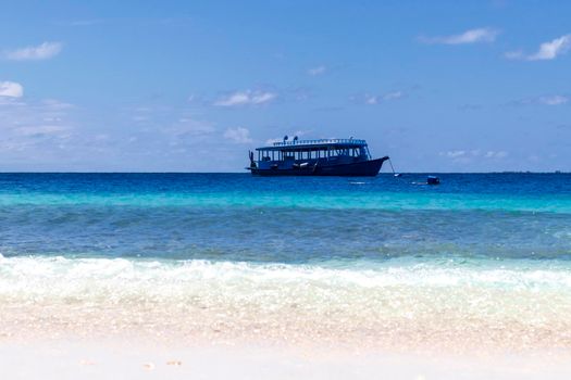 Blue painted boat anchored close to shore.