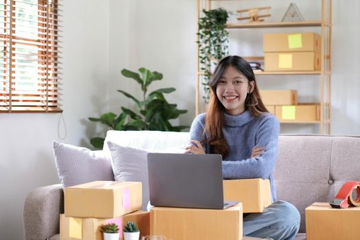 Startup SME small business entrepreneur of freelance asian woman using a laptop with box Cheerful success online marketing packaging box and delivery SME