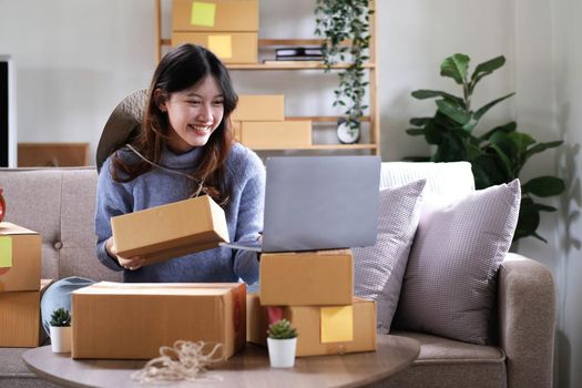 Young woman small business owner working at home office. Online marketing packaging delivery, startup SME entrepreneur or freelance woman concept. Small business owener.