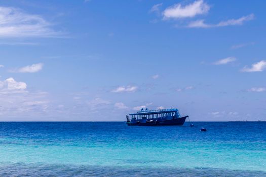 Blue painted boat anchored close to shore.