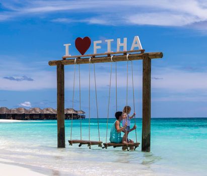 Male, Maldives 04.24.2021 - Kids are playing on the swing at Fihalhohi island resort beach