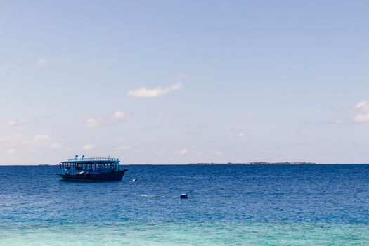 Blue painted boat anchored close to shore.