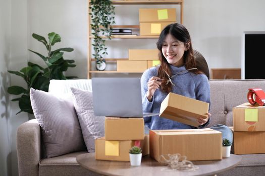 Young woman small business owner working at home office. Online marketing packaging delivery, startup SME entrepreneur or freelance woman concept. Small business owener.