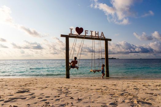 Male, Maldives 04.24.2021 - Kids are playing on the swing at Fihalhohi island resort beach