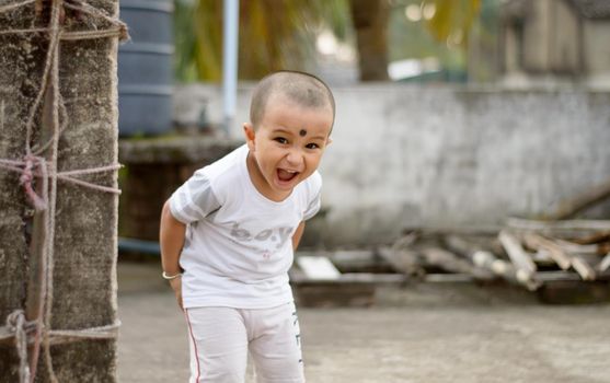 Cute smart naughty baby making a funny and looking at camera. Happy baby background.