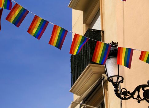 Streets and facades adorned with colorful rainbow flags for The Gay Pride in Benidorm