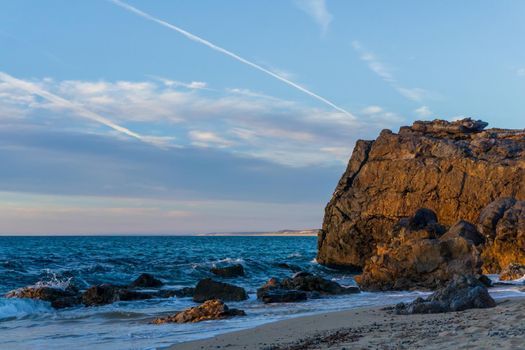 Colorful evening landscape on the beach with rocks background