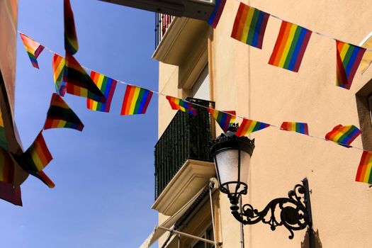 Streets and facades adorned with colorful rainbow flags for The Gay Pride in Benidorm