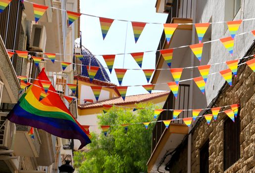 Streets and facades adorned with colorful rainbow flags for The Gay Pride in Benidorm