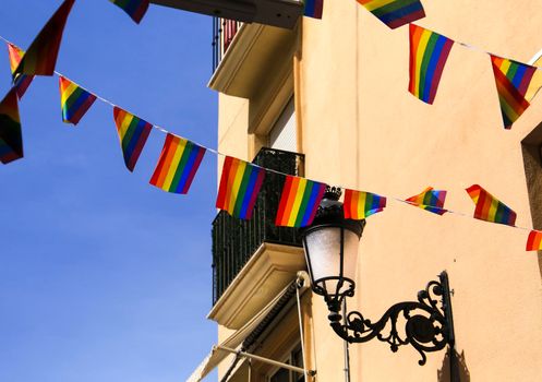 Streets and facades adorned with colorful rainbow flags for The Gay Pride in Benidorm