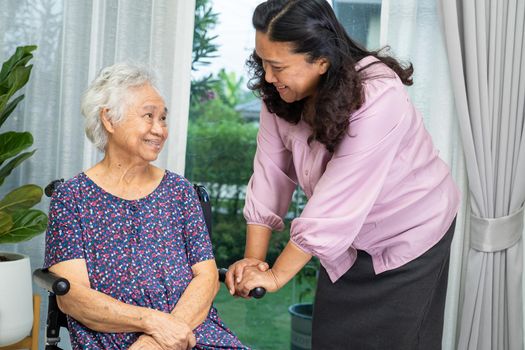 Help and care Asian senior or elderly old lady woman patient sitting on wheelchair at nursing hospital ward, healthy strong medical concept