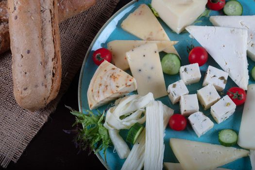 Cheese plate on a dark table. Many kinds of cheese on a plate. High quality photo