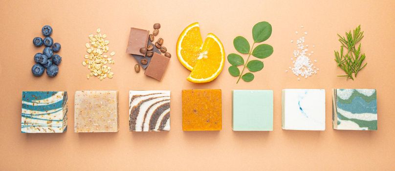Top view of assorted variety of different handmade soap bars with natural ingredients, herbs, berries. Skin care and organic soap making concept, spa cosmetic treatment .