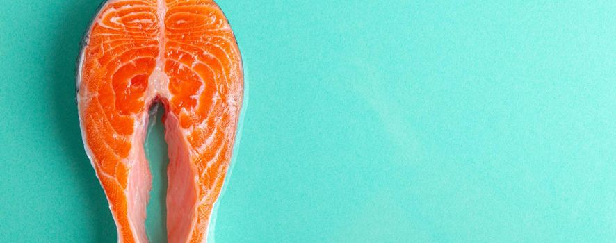 Uncooked raw fresh fish salmon steak top view on blue clean background from above, delicacy healthy fish eating and nutrition concept flat lay space for text