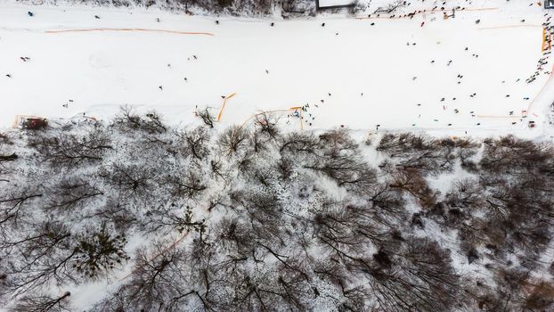 Drone view at slope on ski resort. Forest and ski slope from air. Winter landscape from a drone. Snowy landscape on ski resort. Aerial photography.