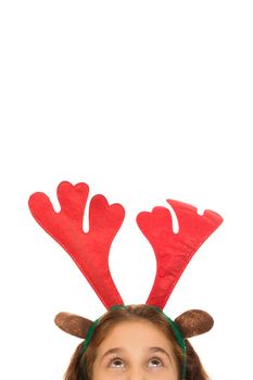 Vertical cropped shot of a little girl wearing Christmas raineer antlers looking at the copyspace above her isolated x-mas holidays news enjoyment childhood new year merry winter kids joy