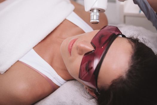 Close up of a woman getting facial hair removed with laser. Epilation, rejuvenation concept