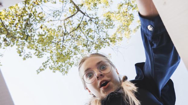 A girl opens a box in the park in admiration