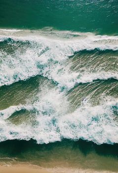 Beach and waves from above. ater background from the top. Summer attacks from the air. Aerial view of a blue ocean