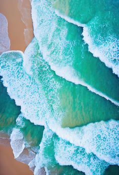 Beach and waves from above. ater background from the top. Summer attacks from the air. Aerial view of a blue ocean