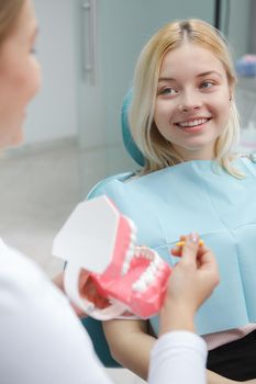 Vertical shot of a cheerful young woman smiling at her dentist sitting in dental chair