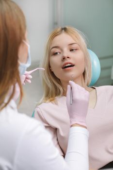 Vertical shot of a young woman getting dental checkup at the clinic