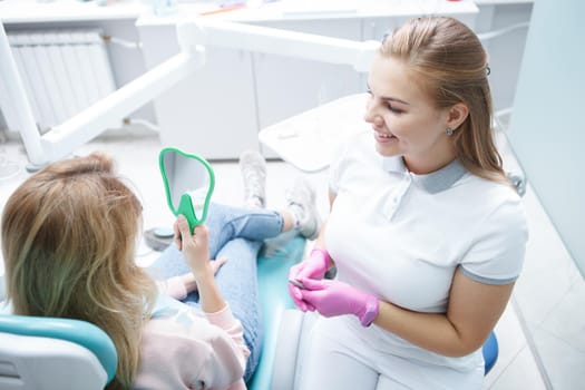 Top view shot of a charming young female dentist talking to her patient after dental checkup