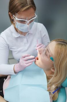 Vertical top view shot of a dentist treating teeth of female patient