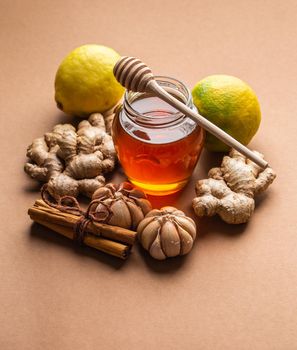 Natural cold and flu home remedies: honey glass pot, ginger, garlic, lemon, cinnamon to boost immune system. Natural healthy food ingredients for immunity stimulation and viruses protection.