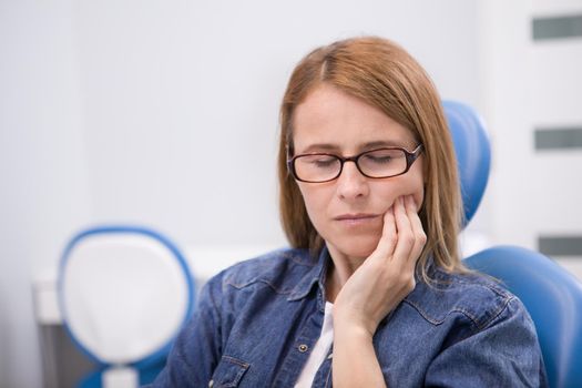Mature woman having toothache, having dental appointment