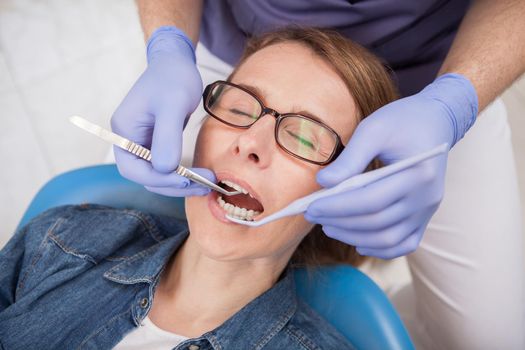 Top view close up of a mature woman getting dental checkup by professional dentist