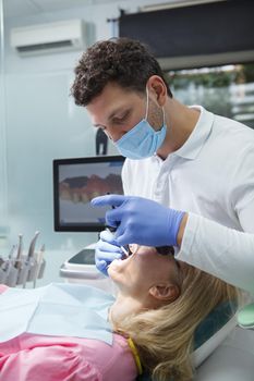 Vertical shot of a dentist doing dental scan of patients teeth