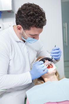 Vertical shot of a professional dentist working with patient