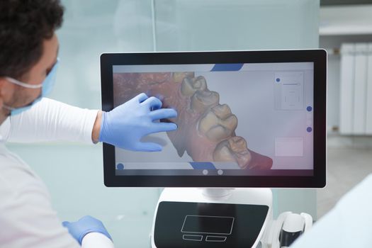 Dentist examining dental scan of a patient on the computer screen
