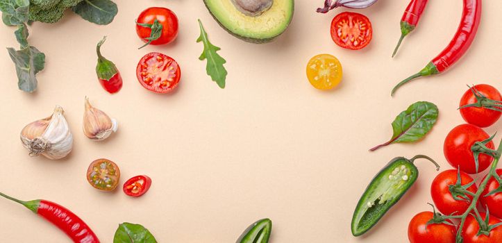 Creative cooking healthy organic food concept background made of colourful fruit and vegetables on beige background flat lay: tomatoes, broccoli, avocado, onion, garlic top view with space for text.