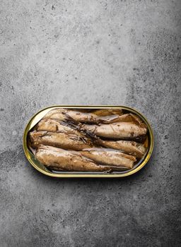 Close up and top view of smoked canned sardine in a tin over gray rustic concrete background. Tinned fish as a convenient, fast, healthy food and source of omega-3 fatty acids, protein and vitamin D