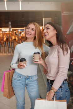 Cheerful lovely women having coffee at the shopping mall enjoying seasona sale