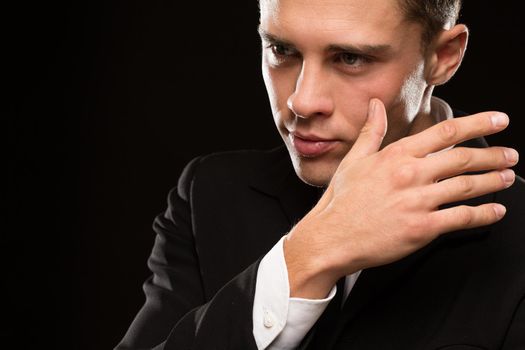 Cropped close up of a handsome young man posing expressively on black background looking to the camera confidently copyspace masculinity power seduction sexuality macho face touch hand