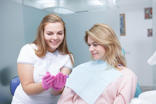 Mature woman learning about teeth whitening from her dentist