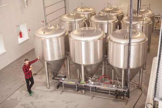 Top view shot of a male brewer tasting beer at his microbrewery, copy space