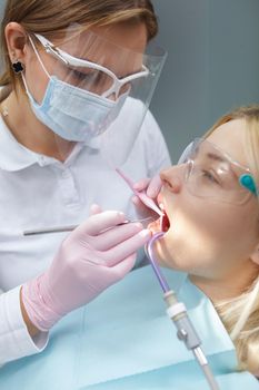 Vertical cropped shot of a woman having dental treatment by professional dentist